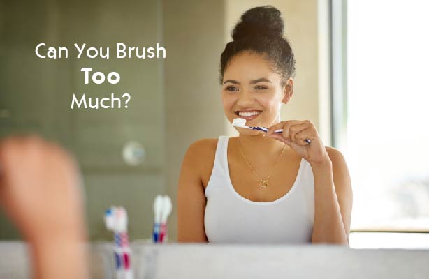 young woman in front of mirror brushing teeth