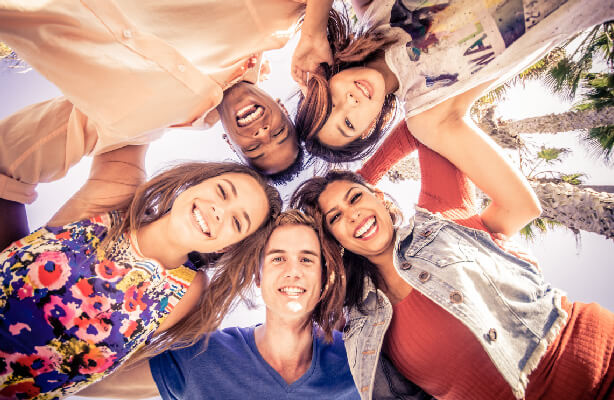 group of young adults in circle looking down