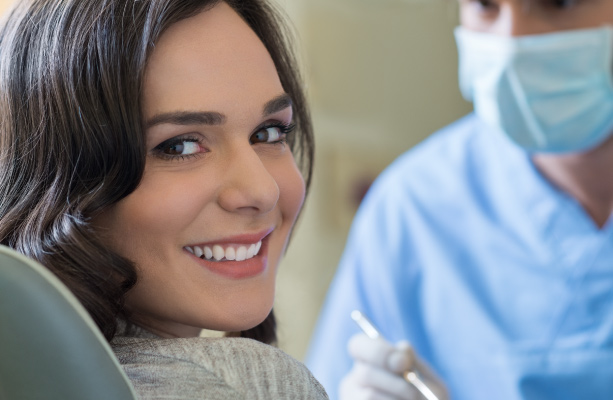 woman in dental chair smiling with dentist behind her