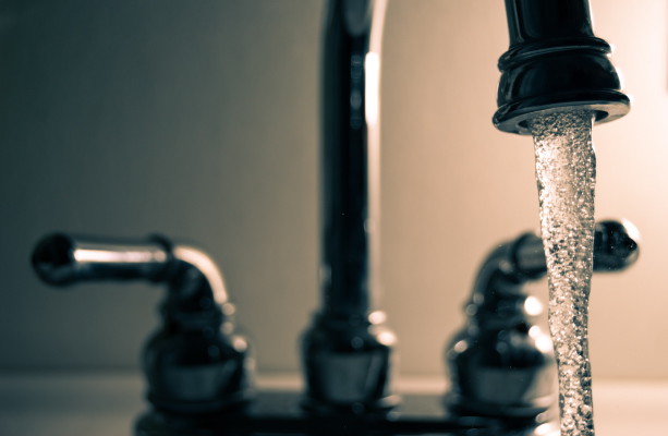 Water runs from a stainless steel bathroom faucet