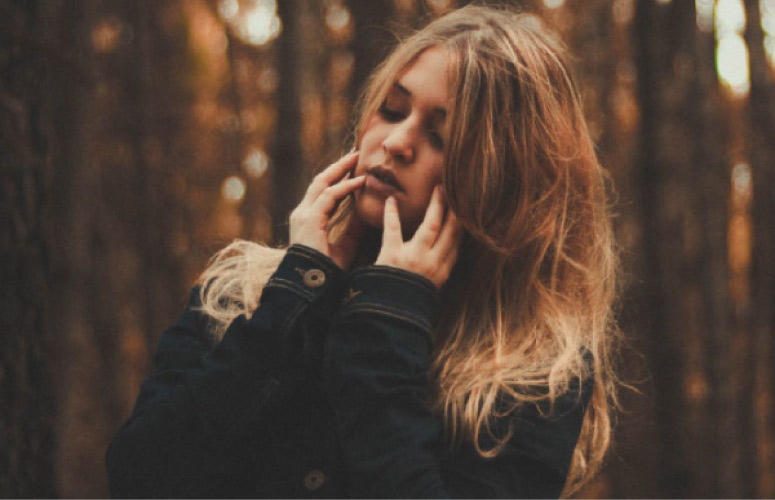 girl holding her jaw with painful gums