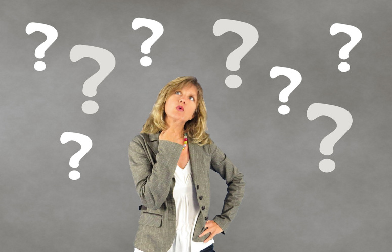 woman surrounded by question marks pondering the purpose of wisdom teeth