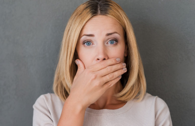 woman covering her mouth with her hand to hide gum recession