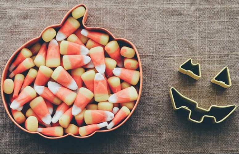 pumpkin shaped bowl full of candycorn