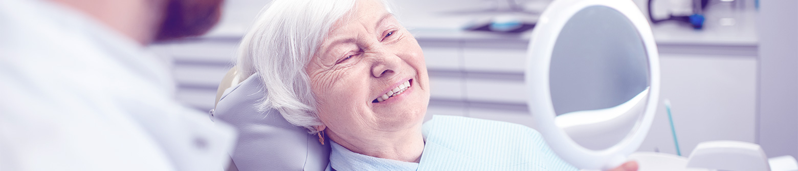 Elderly woman looking at smile in mirror