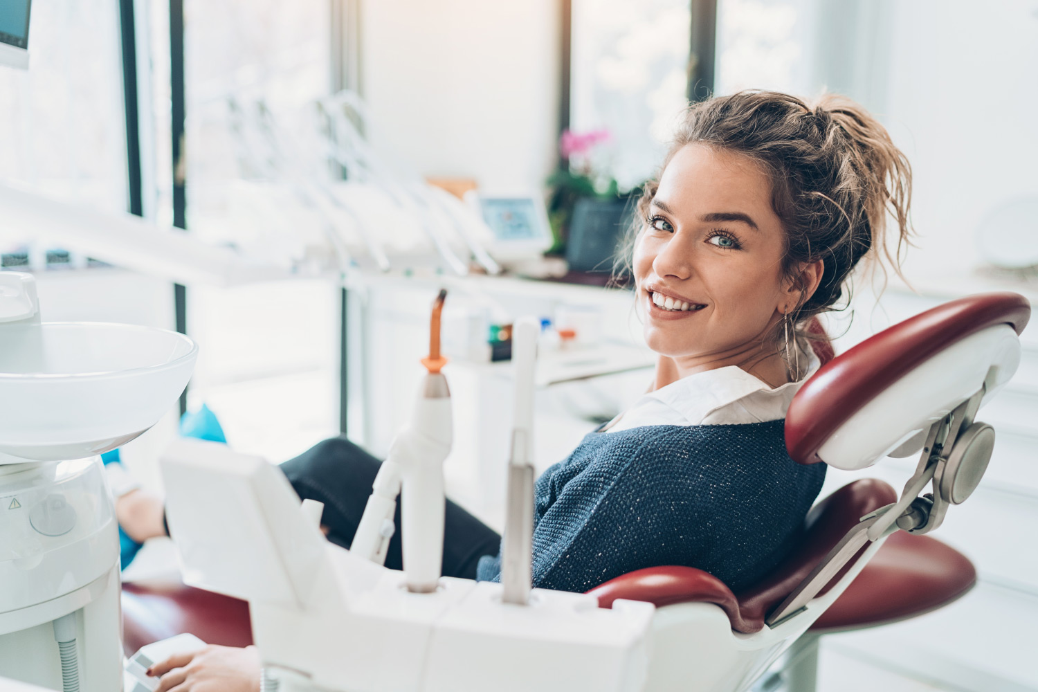 Brunette woman in a dental chair smiles before receiving root canal treatment in Canton, GA