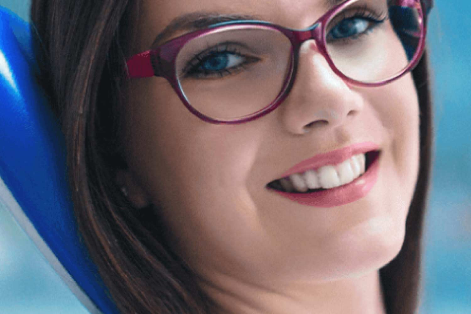 young woman wearing glasses sits in the dentist chair after geeting onlays on her teeth.