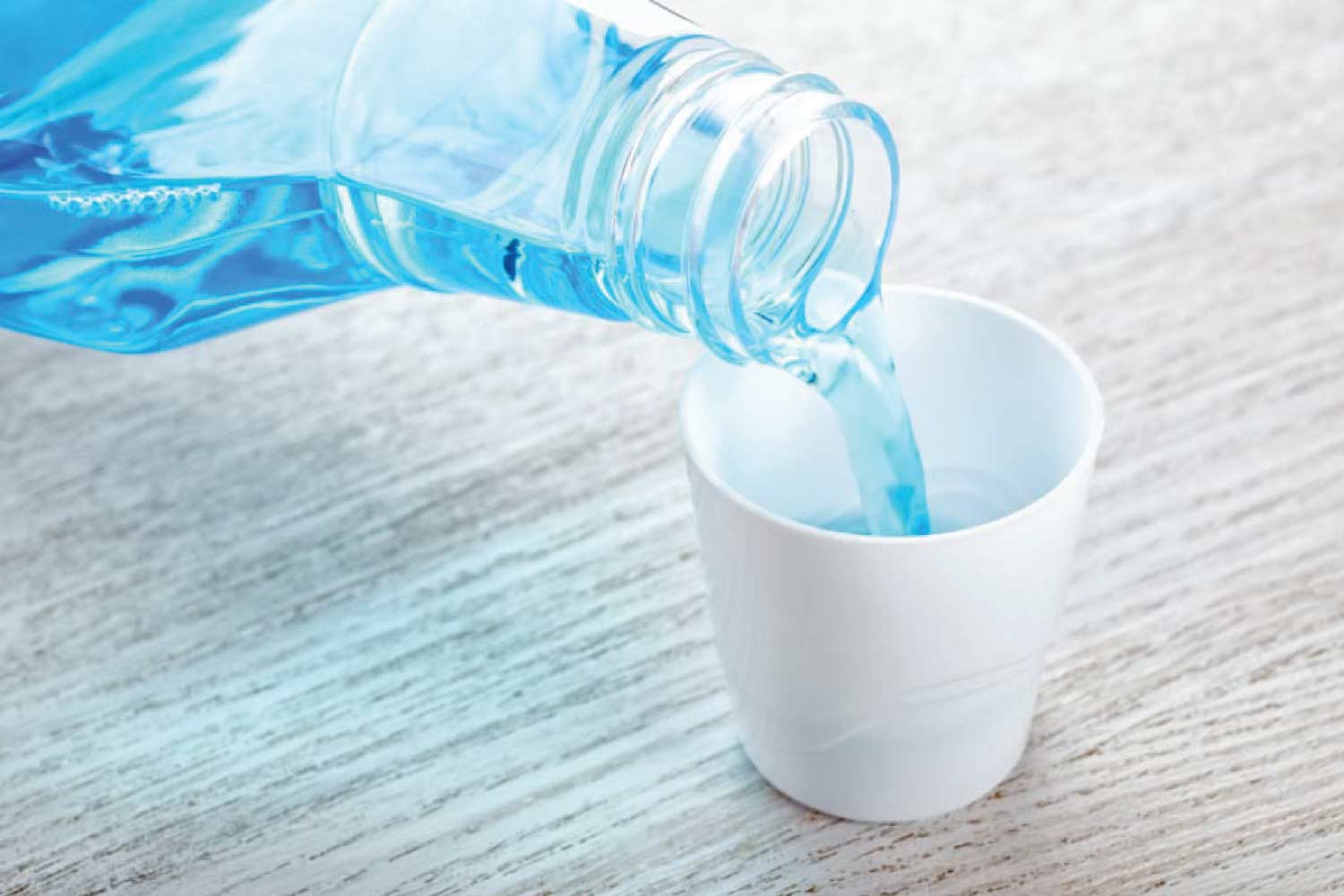 mouthwash being poured into a small cup