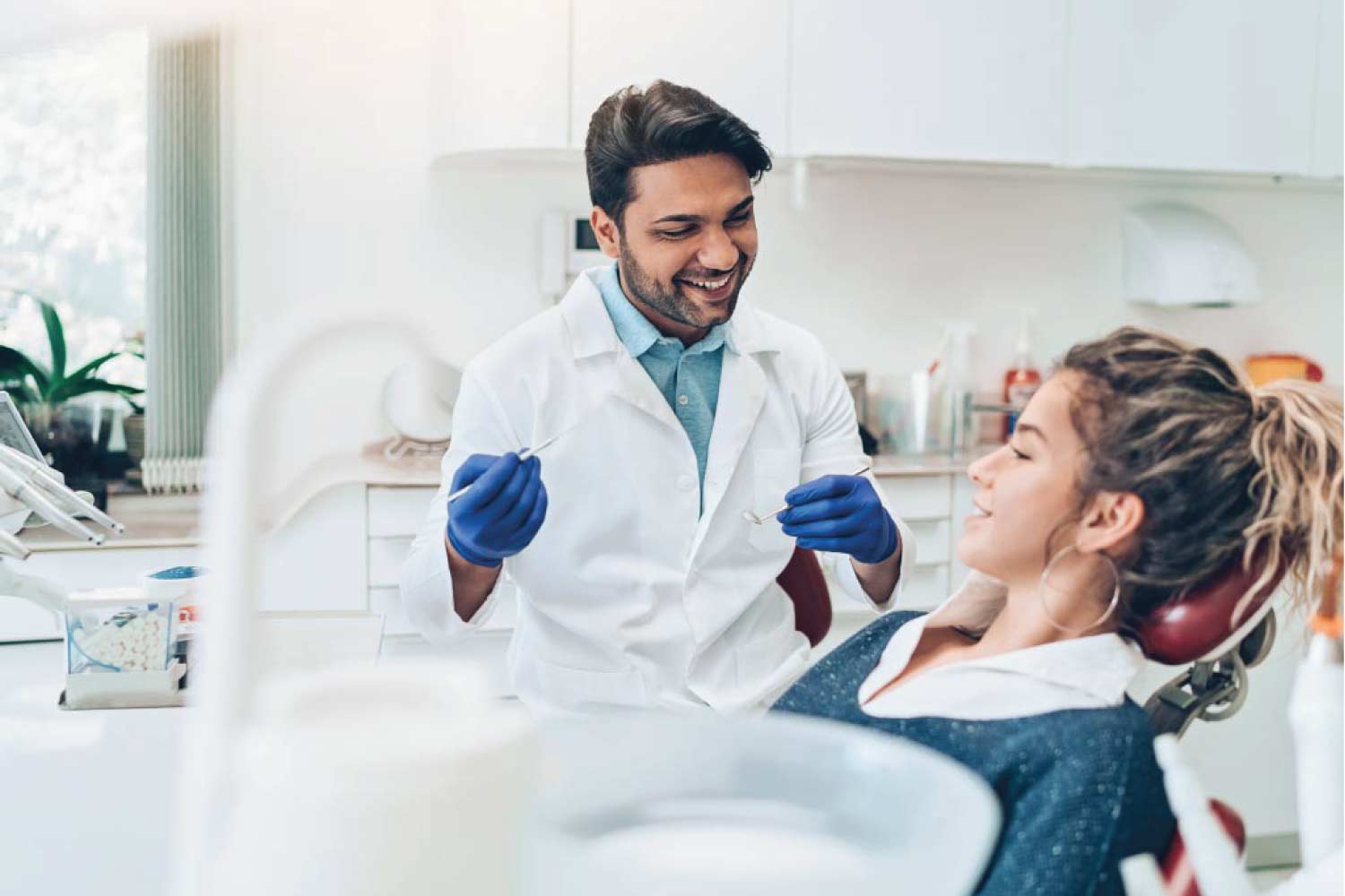 young woman in the dentist chair gets a routine exam and cleaning